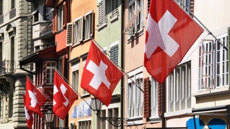 Old street in Zurich decorated with flags for the Swiss National